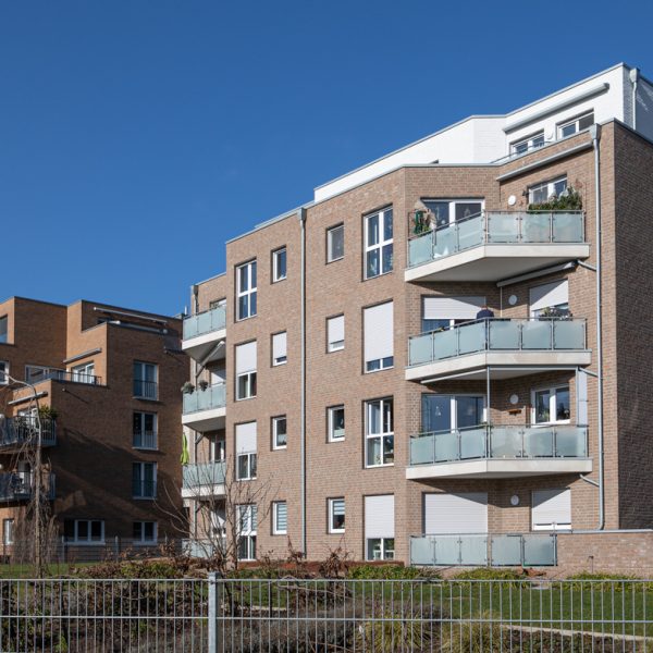 Modernes Mehrfamilienhaus in Emmerich am Rhein m it hellem Klinker und Balkonen.